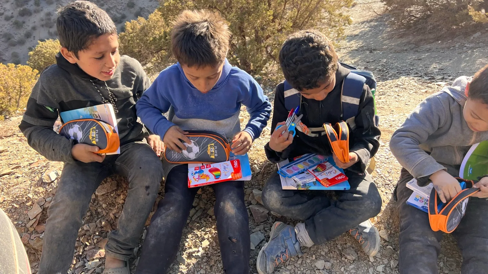 Children open new pencil cases and learning materials during the November 2024 mission