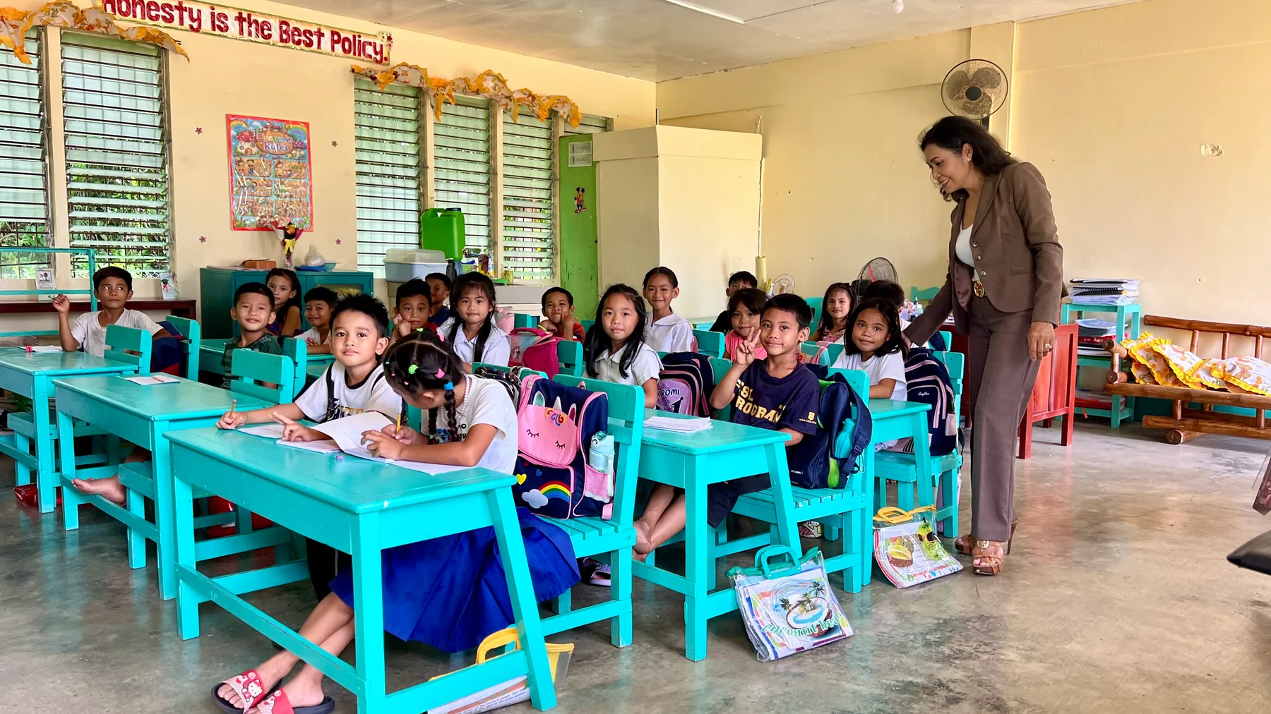 Maribeth de Montaigne talks with children in a classroom during the Iloilo follow-up